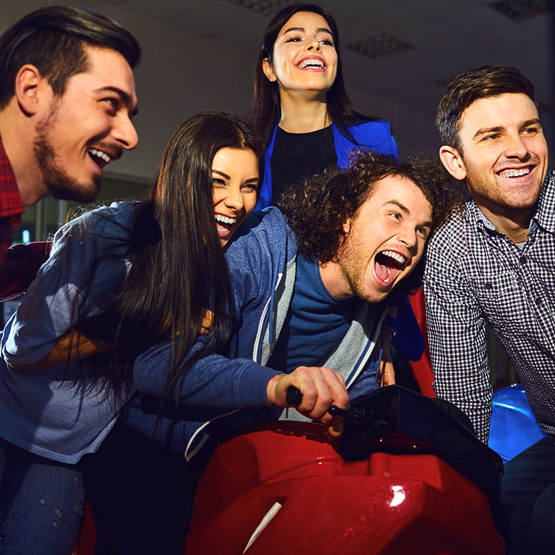 Grupo de amigos se divierte jugando en máquinas de Arcade